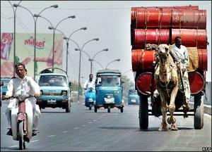 A camel driven cart joins traffic on a busy Karachi road. Image courtesy: BBC